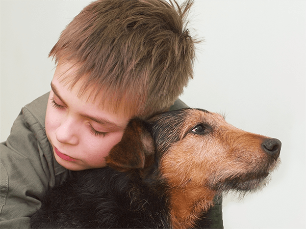 A young boy hugging his precious black and tan dog